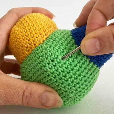 Picture of needle in amigurumi pulling the yarn tails inside