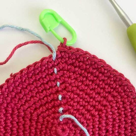 Picture of locking plastic stitch marker securing working loop of crochet